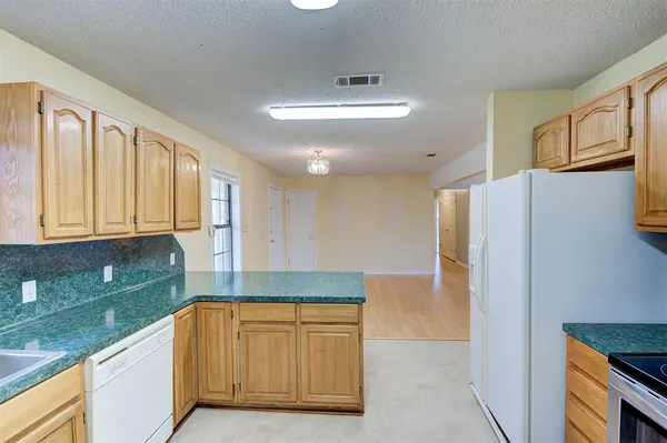 a kitchen with granite countertop a refrigerator and a sink