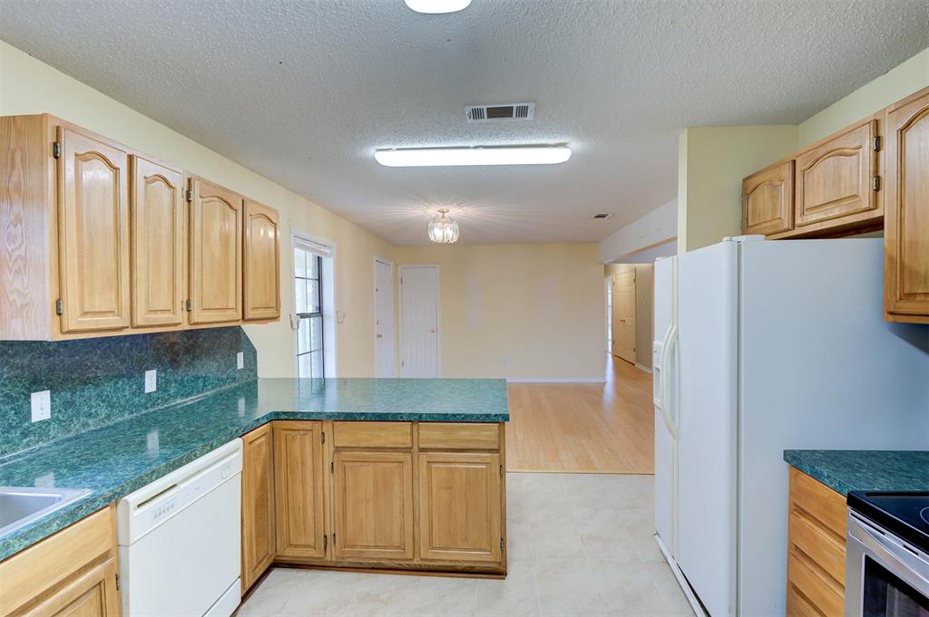 119 Beech Street Homer, LA 71040 - Photo 13 of 21 a kitchen with granite countertop a refrigerator and a sink