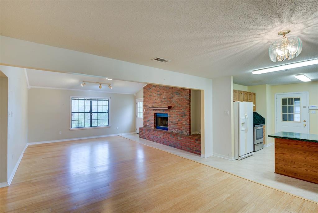119 Beech Street Homer, LA 71040 - Photo 7 of 21 an empty room with wooden floor fireplace and windows