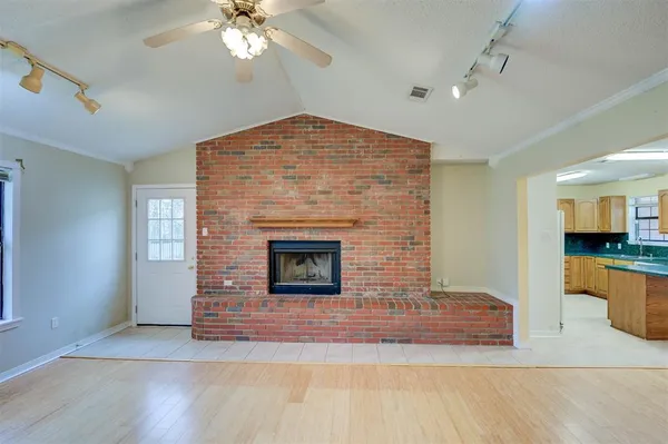 a view of an empty room with a fireplace and a window