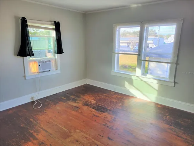 wooden floor in an empty room with a window