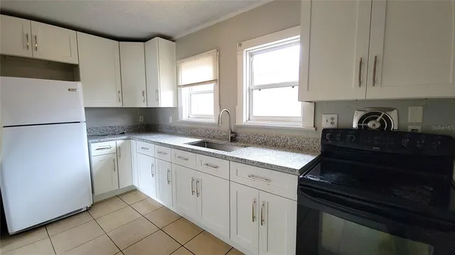 a kitchen with granite countertop white cabinets and white appliances