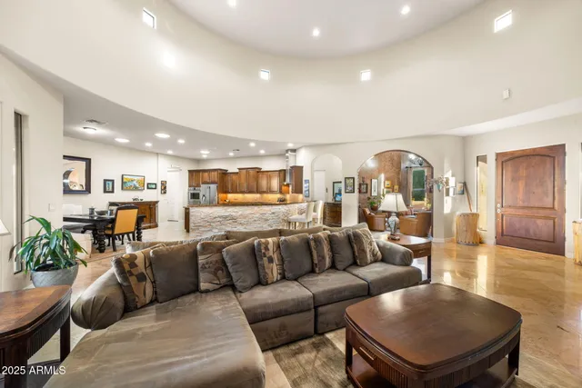 a living room with stainless steel appliances kitchen island granite countertop furniture a rug kitchen view and a fireplace