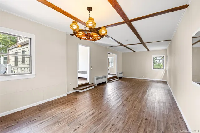 a view of a room with wooden floor and chandelier