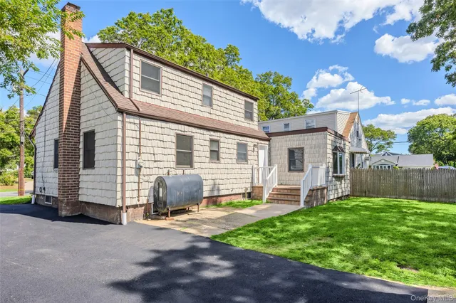 a view of a house with backyard and sitting area