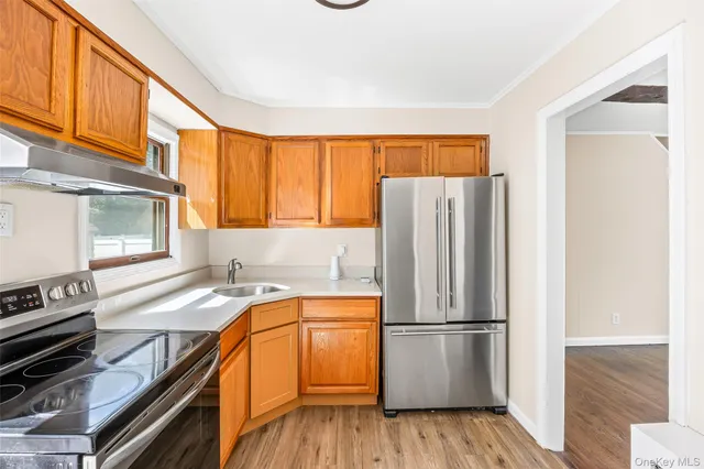 a kitchen with a refrigerator a stove and wooden cabinets