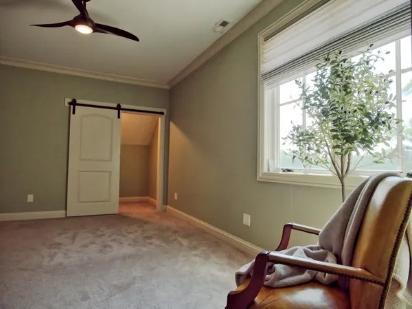 a view of staircase with lots of frames on wall and a window