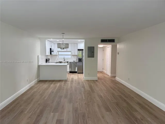 a view of a kitchen with a sink cabinets and wooden floor