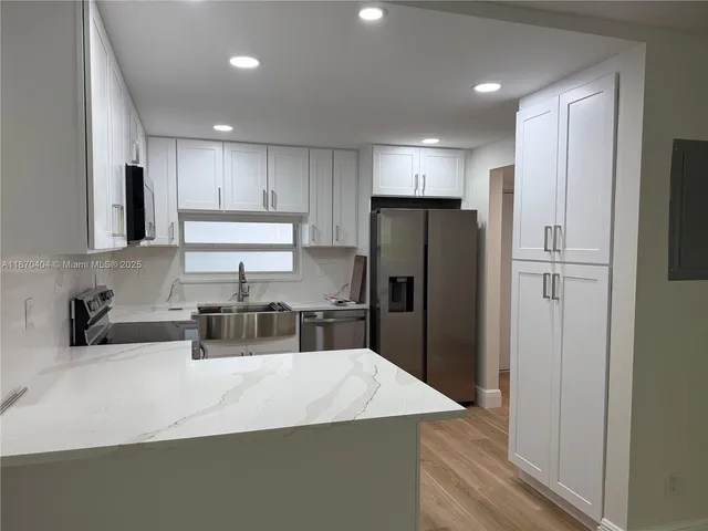 a kitchen with refrigerator and cabinets