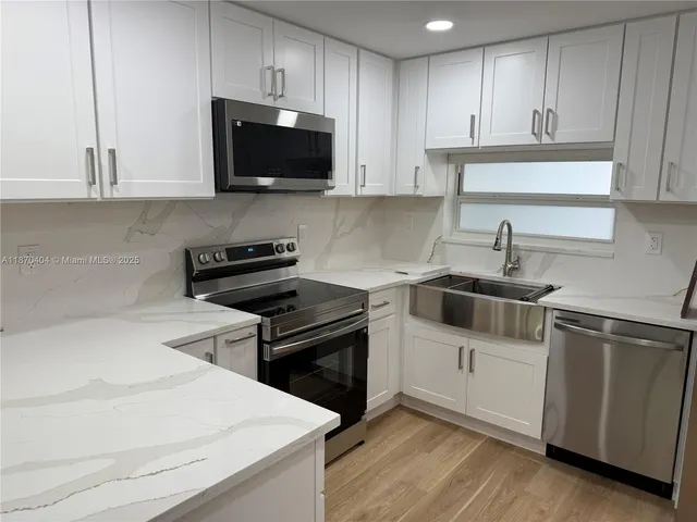a kitchen with a sink and a stove top oven