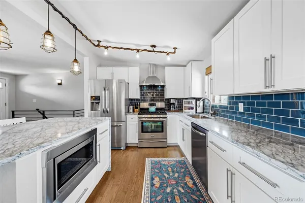 a view of kitchen with stainless steel appliances granite countertop stove and cabinets