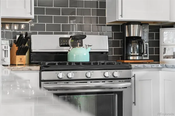 a kitchen with a stove a sink and a window