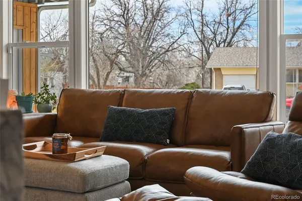 a living room with furniture dining table wooden floor and a view of kitchen