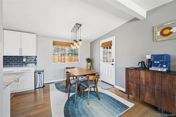 a living room with furniture a rug kitchen view and a chandelier
