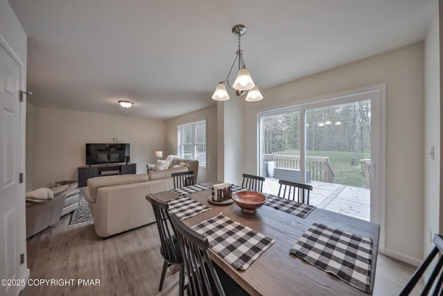 a dining room with furniture a chandelier and wooden floor