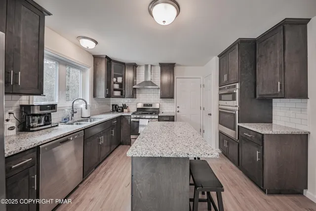 a large kitchen with a center island and stainless steel appliances