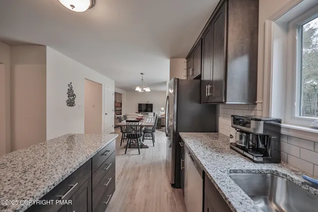 a kitchen with stainless steel appliances granite countertop sink stove top oven and cabinets