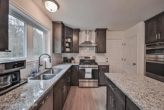a kitchen with stainless steel appliances granite countertop a sink stove and refrigerator