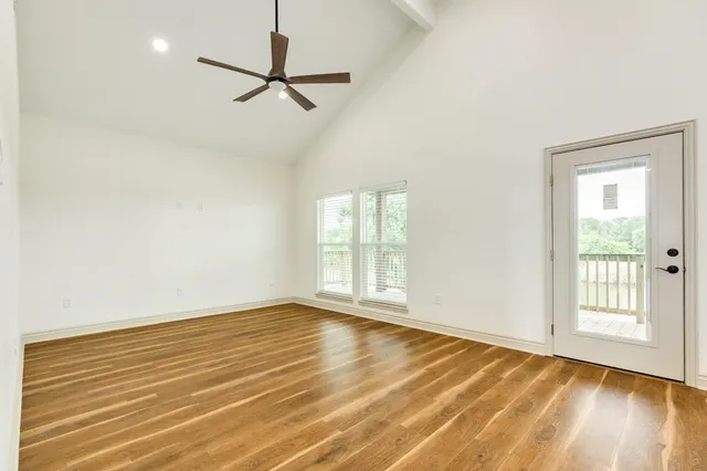 a view of a room with wooden floor and a ceiling fan