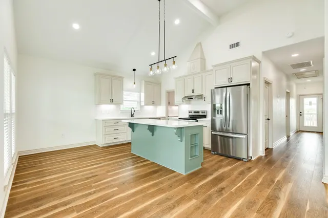 a kitchen with a refrigerator sink and cabinets