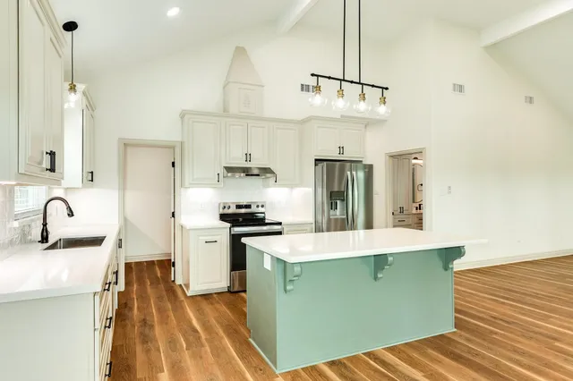 a kitchen with granite countertop a sink appliances and cabinets