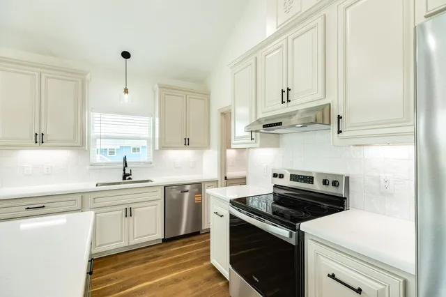 a kitchen with cabinets appliances a sink and a counter top