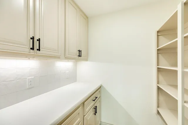 a view of a kitchen with white cabinets