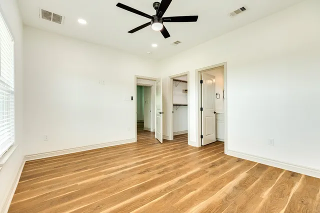 a view of a livingroom with a ceiling fan & entryway