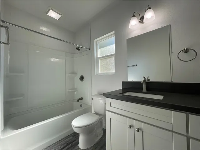 a bathroom with a sink a toilet a mirror and shower