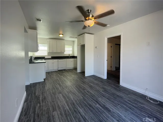 a large kitchen with a wooden floor and stainless steel appliances