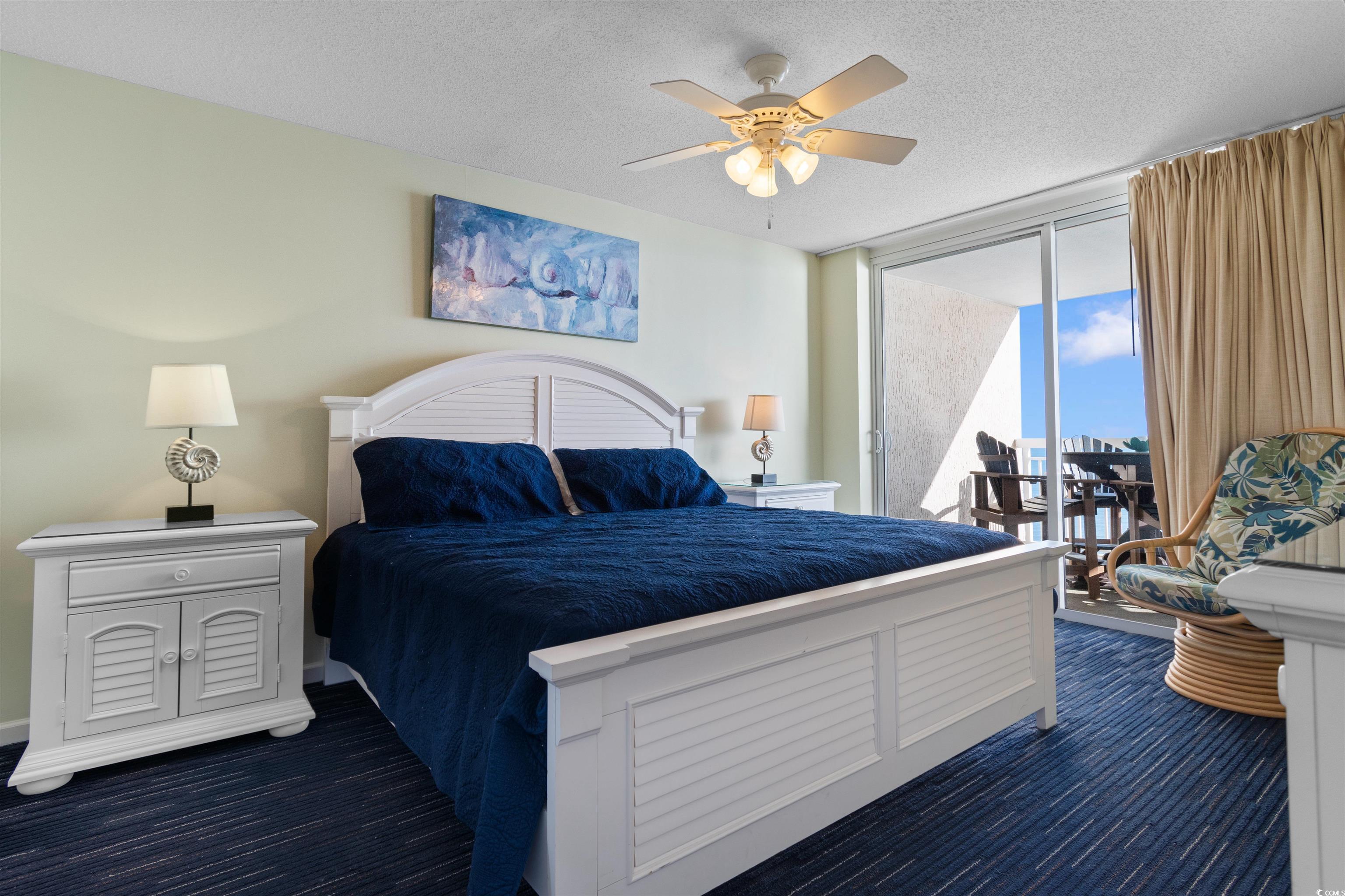 1625 South Ocean Boulevard, Unit 1603 North Myrtle Beach, SC 29582 - Photo 13 of 39 Bedroom featuring access to outside, a textured ceiling, a ceiling fan, dark carpet, and a wall of windows