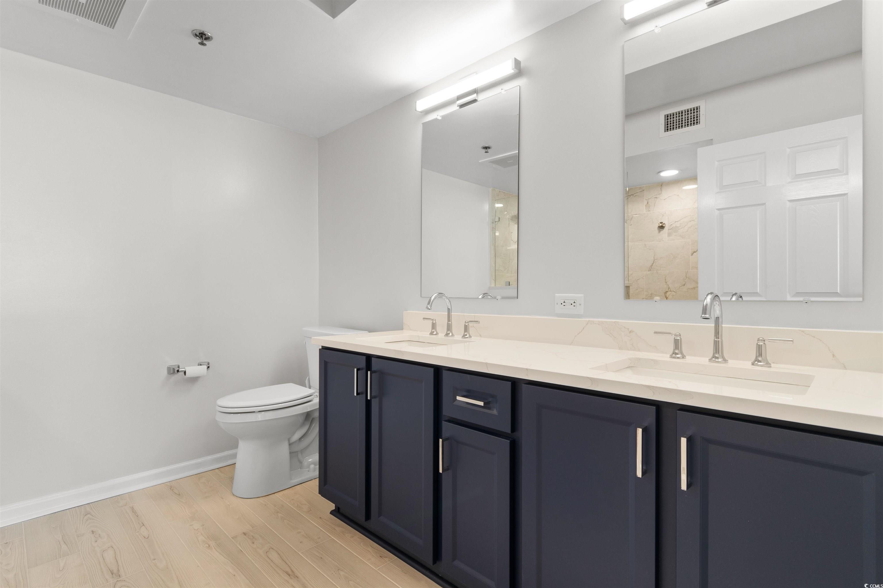 1625 South Ocean Boulevard, Unit 1603 North Myrtle Beach, SC 29582 - Photo 14 of 39 Bathroom with light wood finished floors, double vanity, and a tile shower