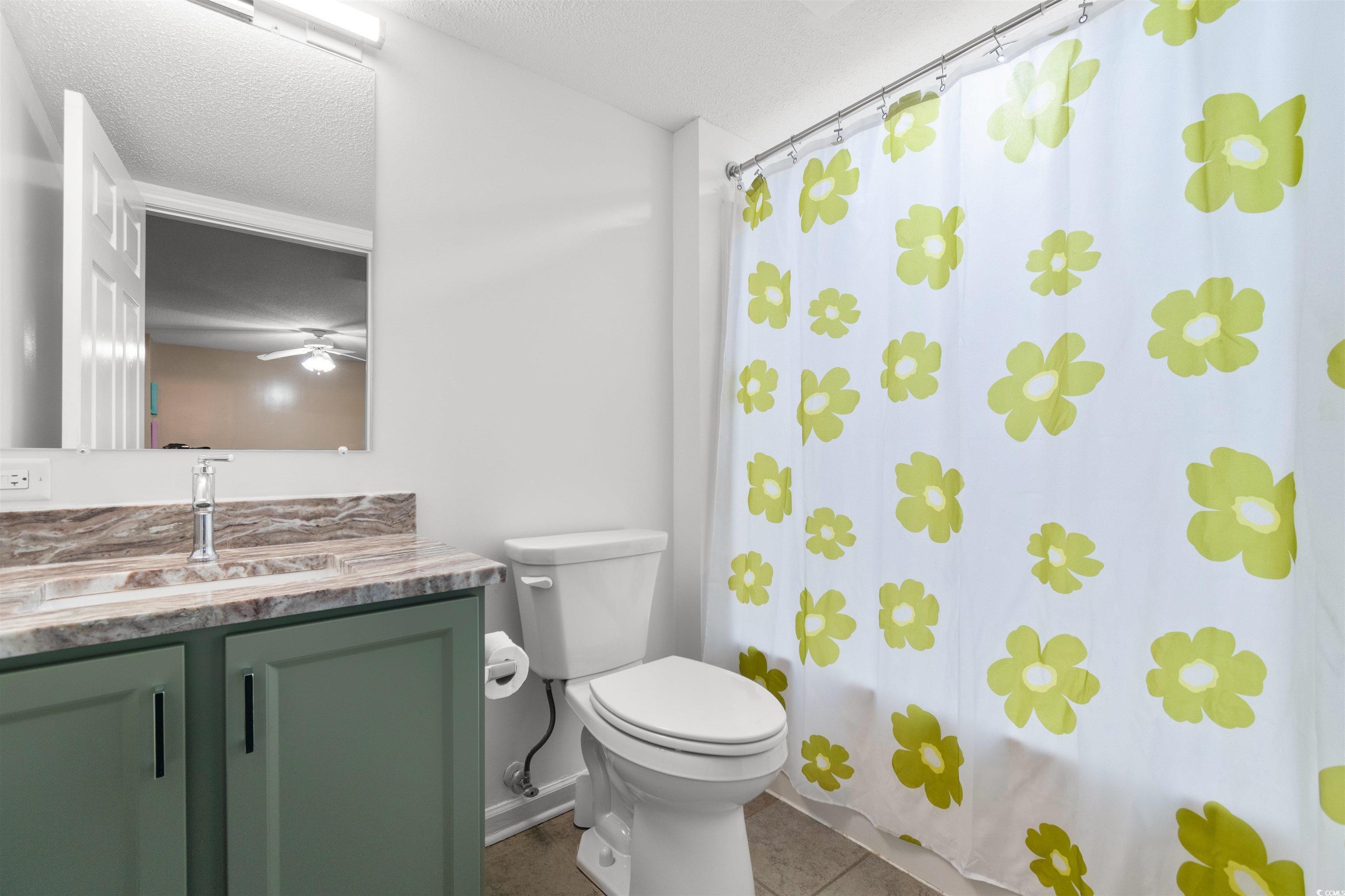 1625 South Ocean Boulevard, Unit 1603 North Myrtle Beach, SC 29582 - Photo 18 of 39 Bathroom with vanity, shower / tub combo with curtain, a textured ceiling, tile patterned floors, and a ceiling fan