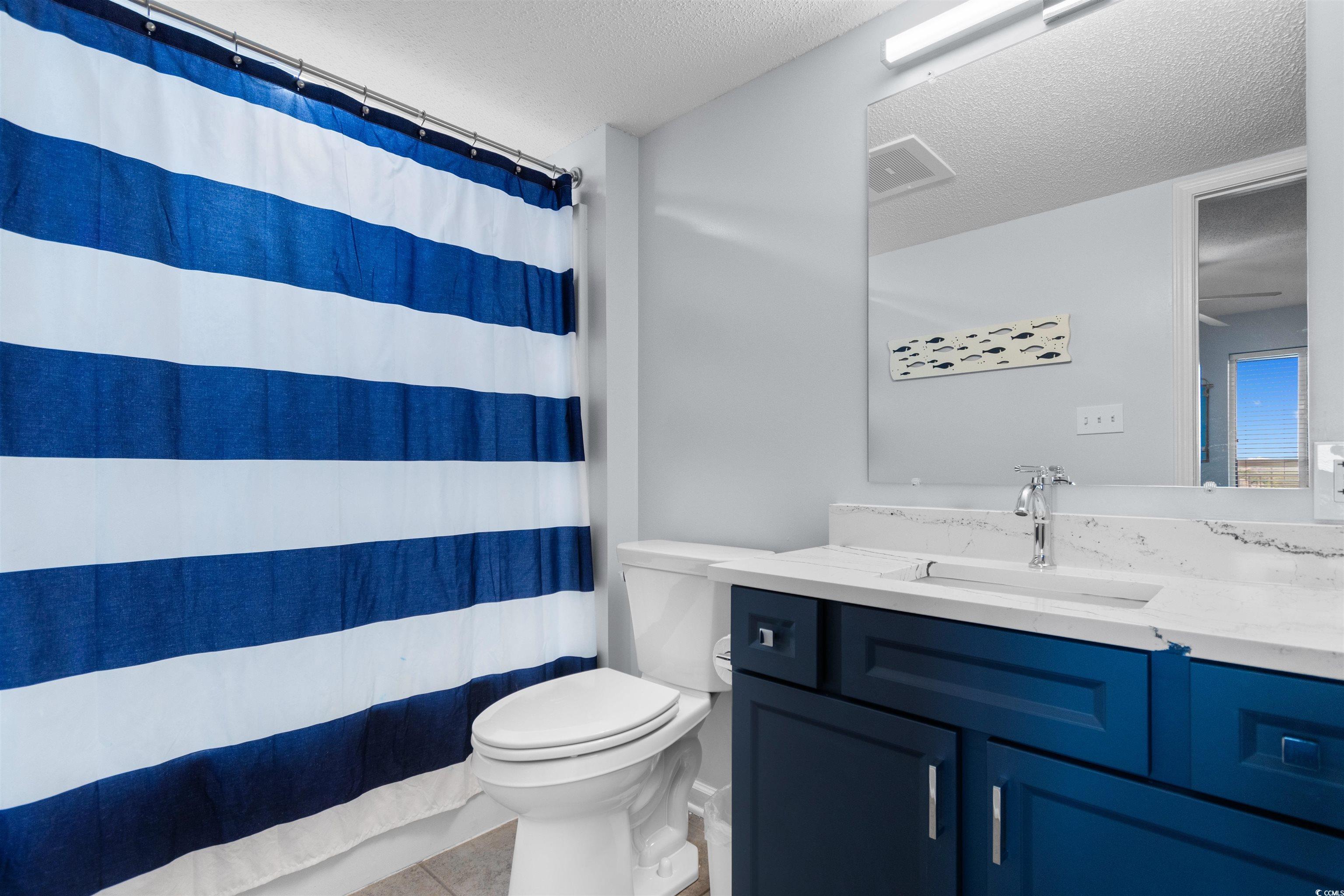 1625 South Ocean Boulevard, Unit 1603 North Myrtle Beach, SC 29582 - Photo 26 of 39 Full bathroom featuring a textured ceiling, vanity, light tile patterned flooring, and shower / bath combination with curtain