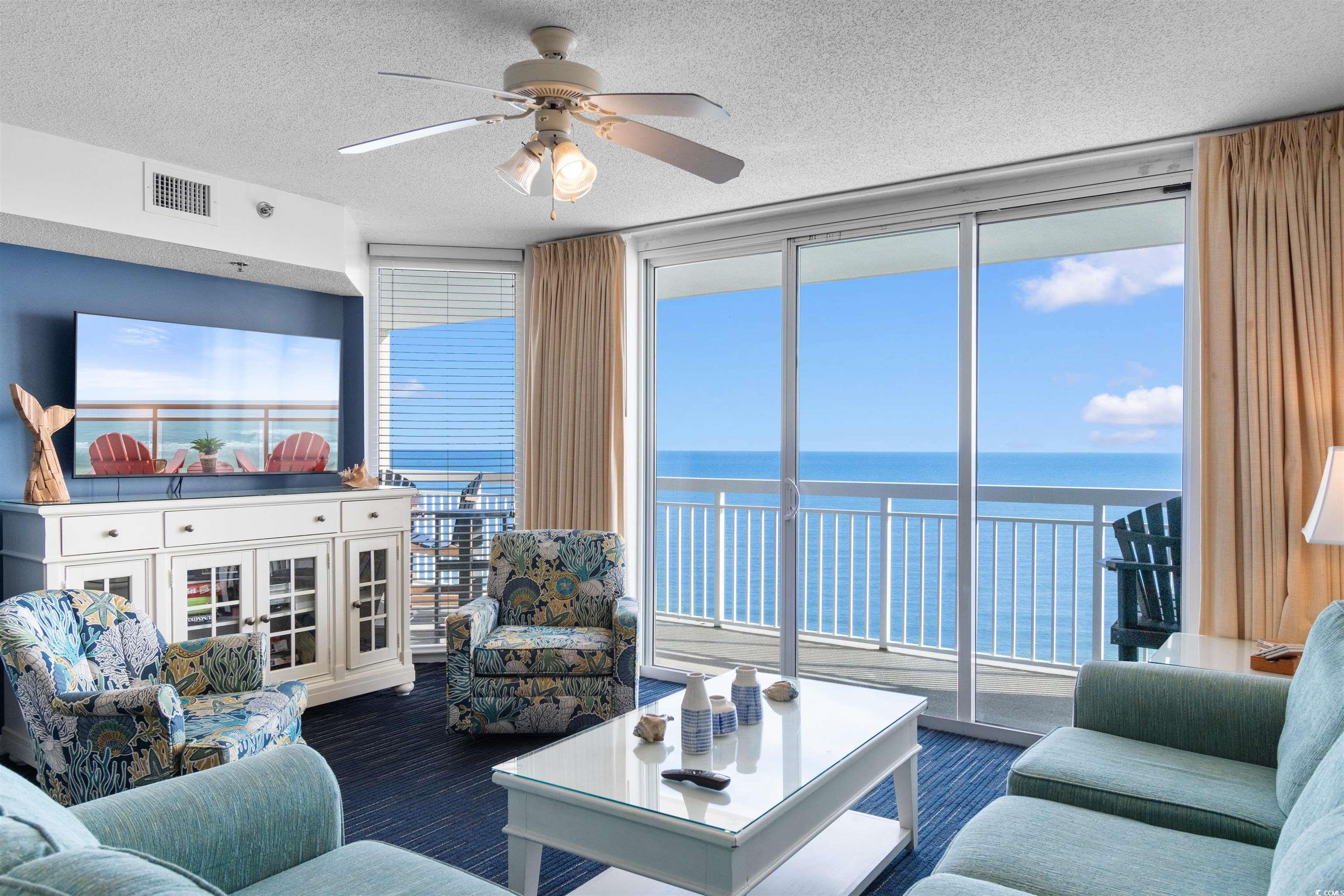 1625 South Ocean Boulevard, Unit 1603 North Myrtle Beach, SC 29582 - Photo 5 of 39 Living area with expansive windows, a water view, a textured ceiling, and a ceiling fan