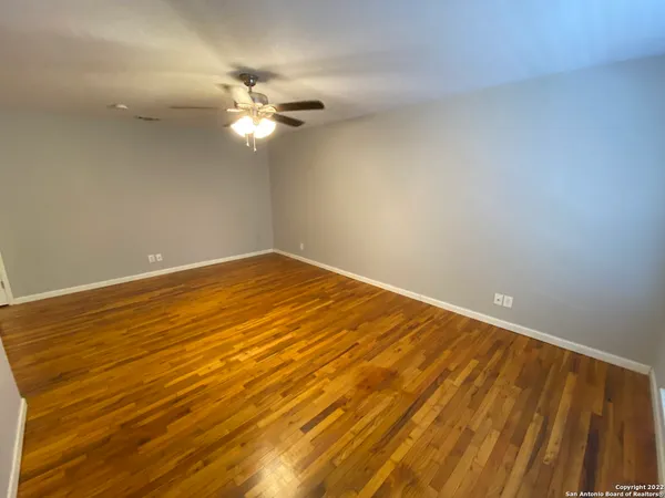a view of an empty room with wooden floor