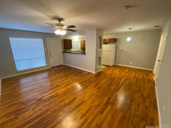 a view of empty room with wooden floor