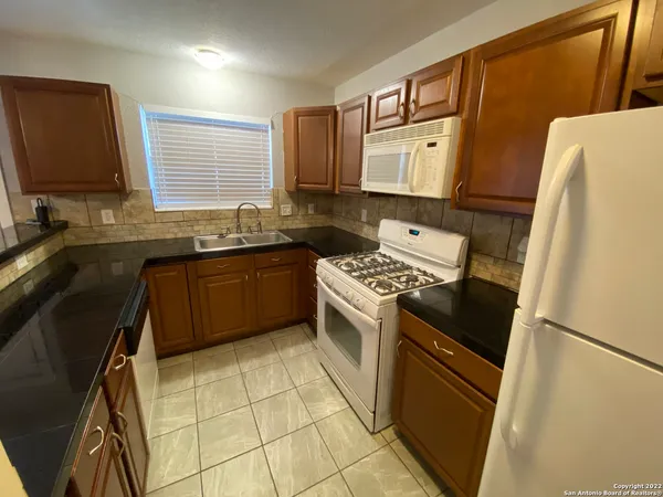 a kitchen with stainless steel appliances granite countertop a refrigerator stove sink and a refrigerator