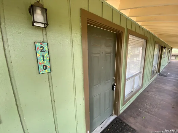 a view of a hallway with wooden floor and door