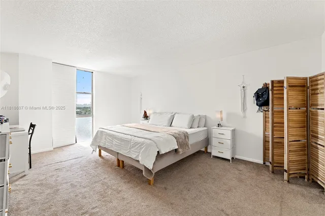 a spacious bedroom with a bed and a flat screen tv