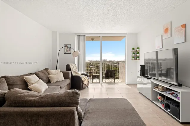 a living room with furniture a flat screen tv and a floor to ceiling window