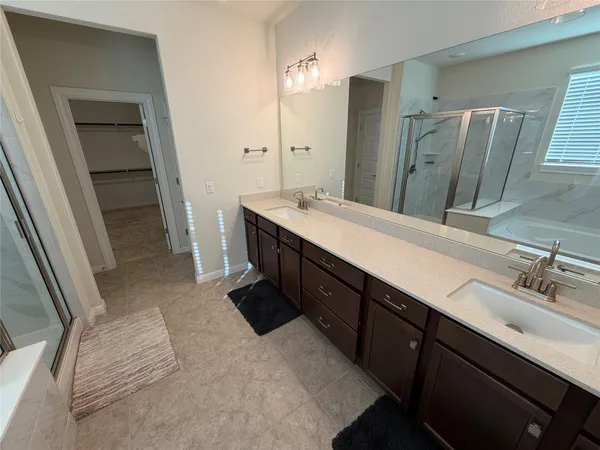 a spacious bathroom with double vanity and a mirror