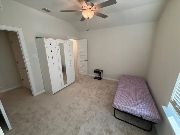 a bedroom with a bed and a ceiling fan