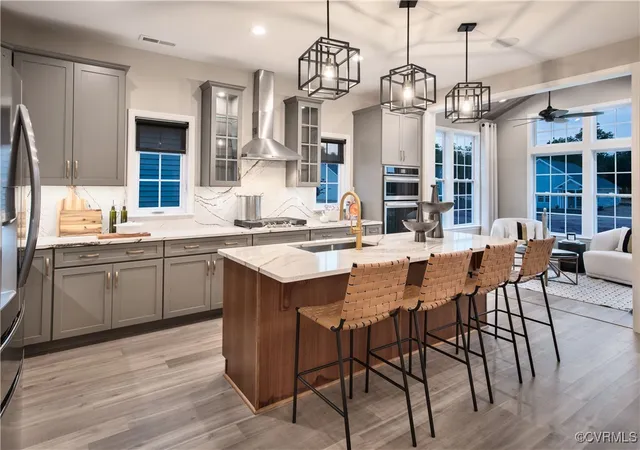 a kitchen with stainless steel appliances kitchen island granite countertop a sink a stove a dining table and chairs
