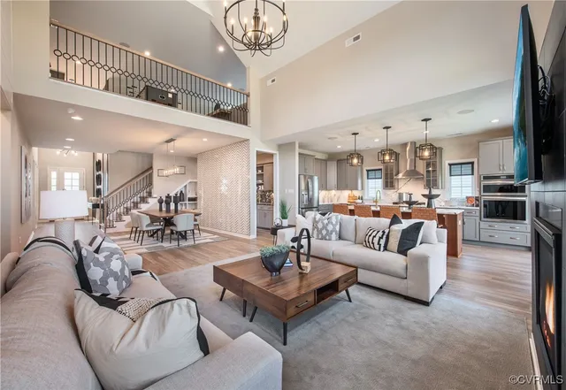 a living room with furniture kitchen view and a chandelier