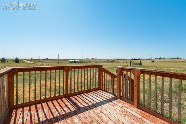 6240 Night Train Lane Yoder, CO 80864 - Photo 42 of 50 Wooden terrace featuring a rural view and a lawn
