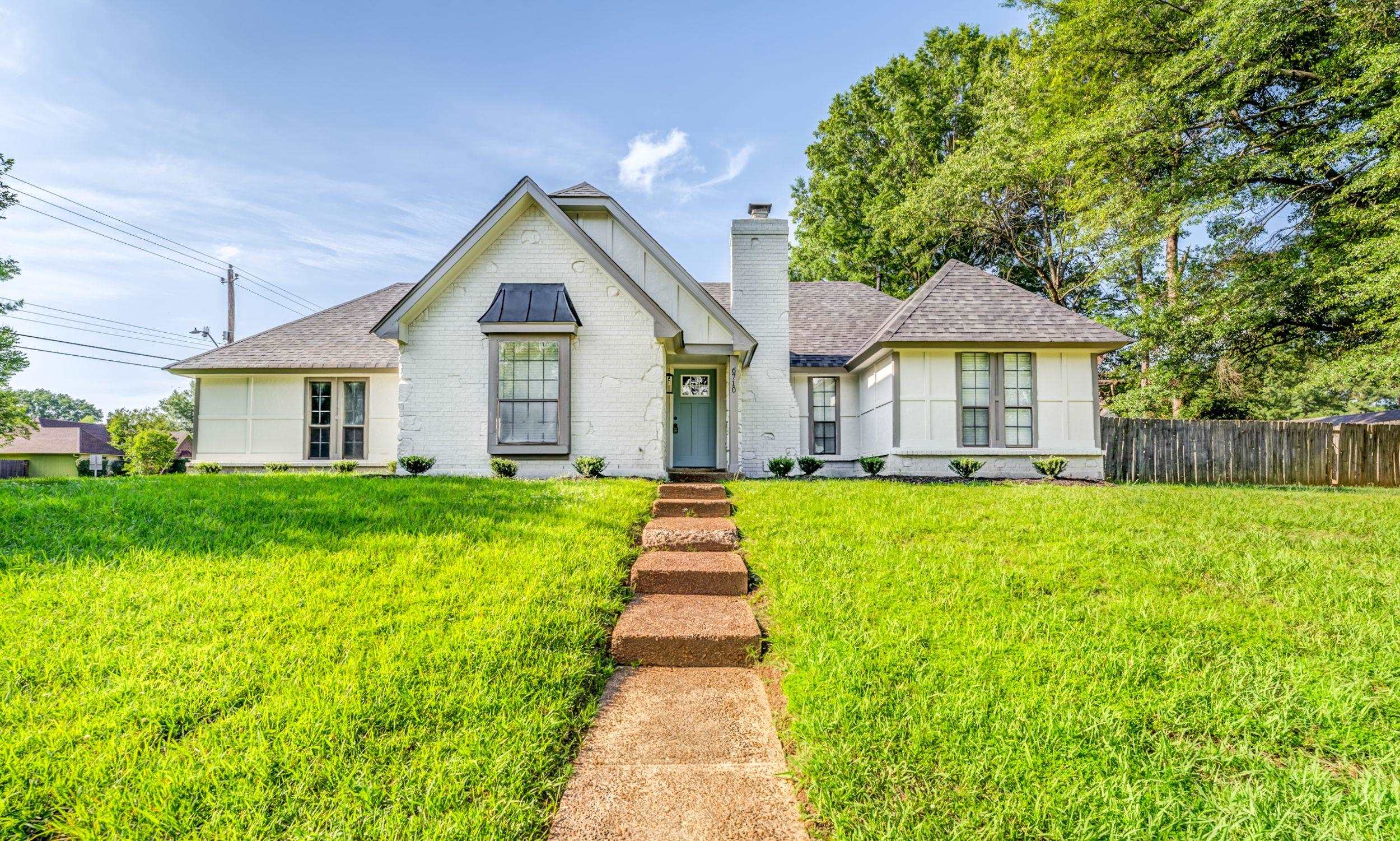 6710 Rockingham Road Memphis, TN 38141 - Photo 1 of 12 a view of a house with a big yard plants and large trees
