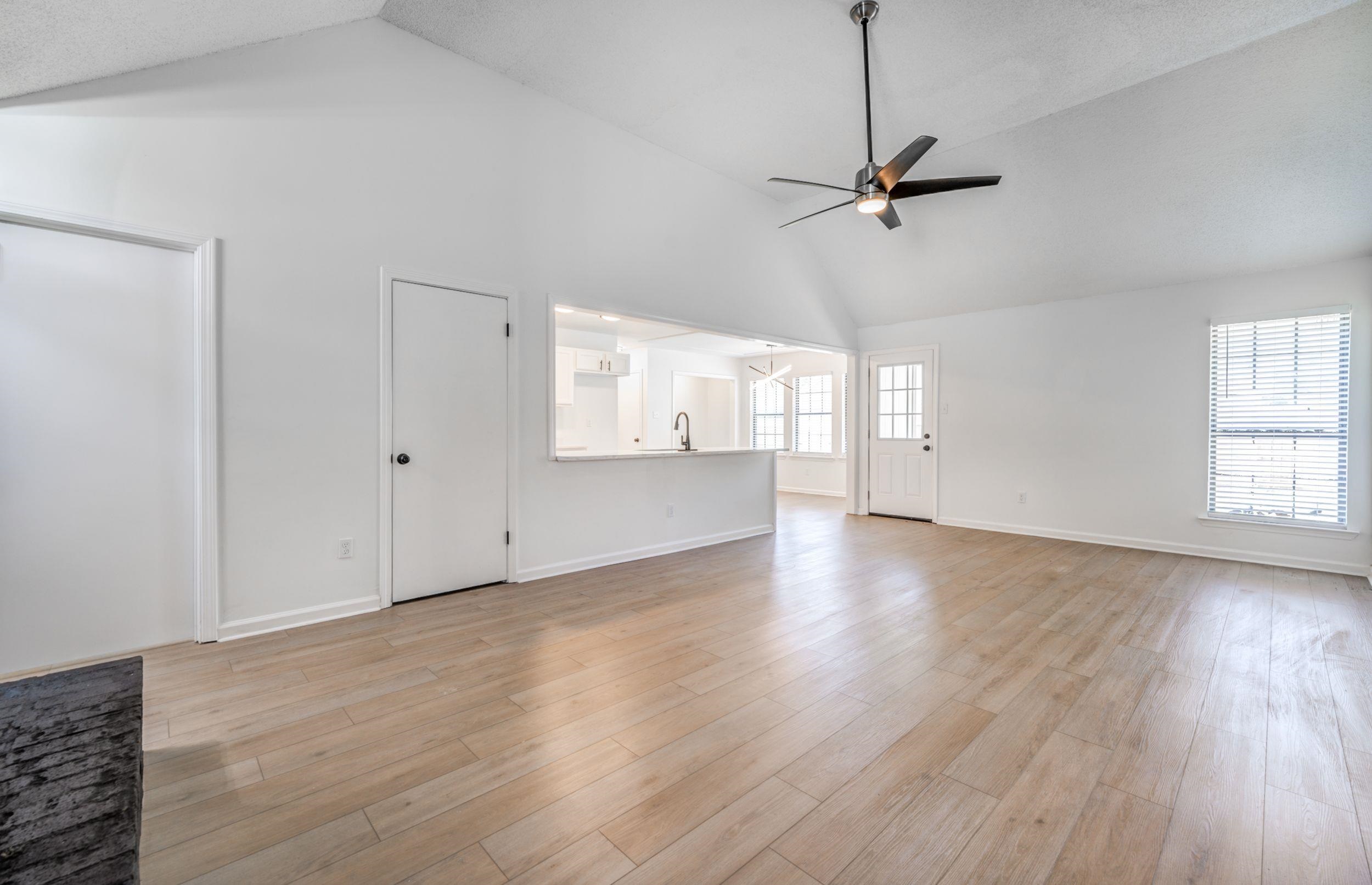 6710 Rockingham Road Memphis, TN 38141 - Photo 3 of 12 a view of an empty room with wooden floor and a window