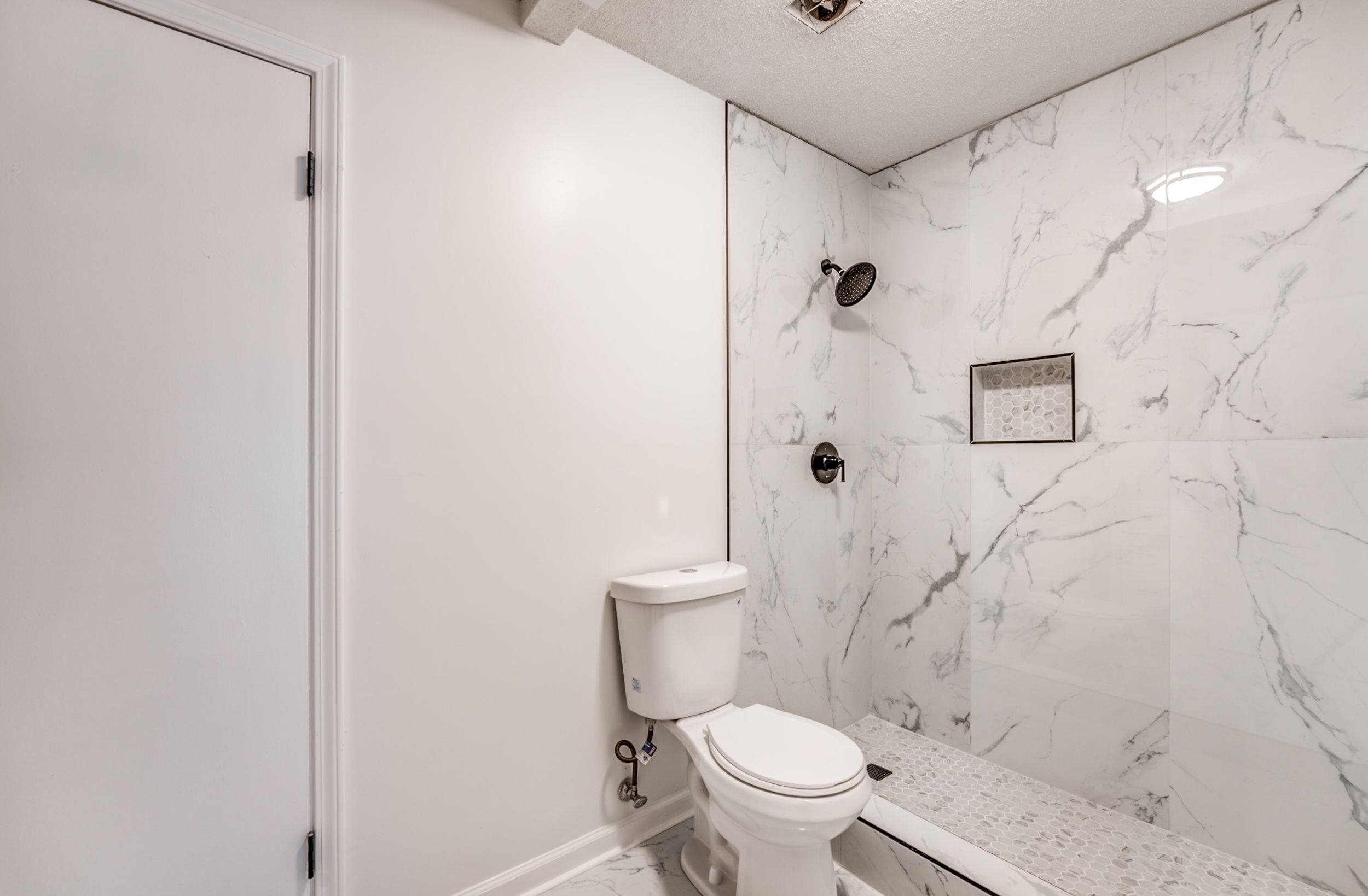 6710 Rockingham Road Memphis, TN 38141 - Photo 9 of 12 a white toilet sitting next to a shower
