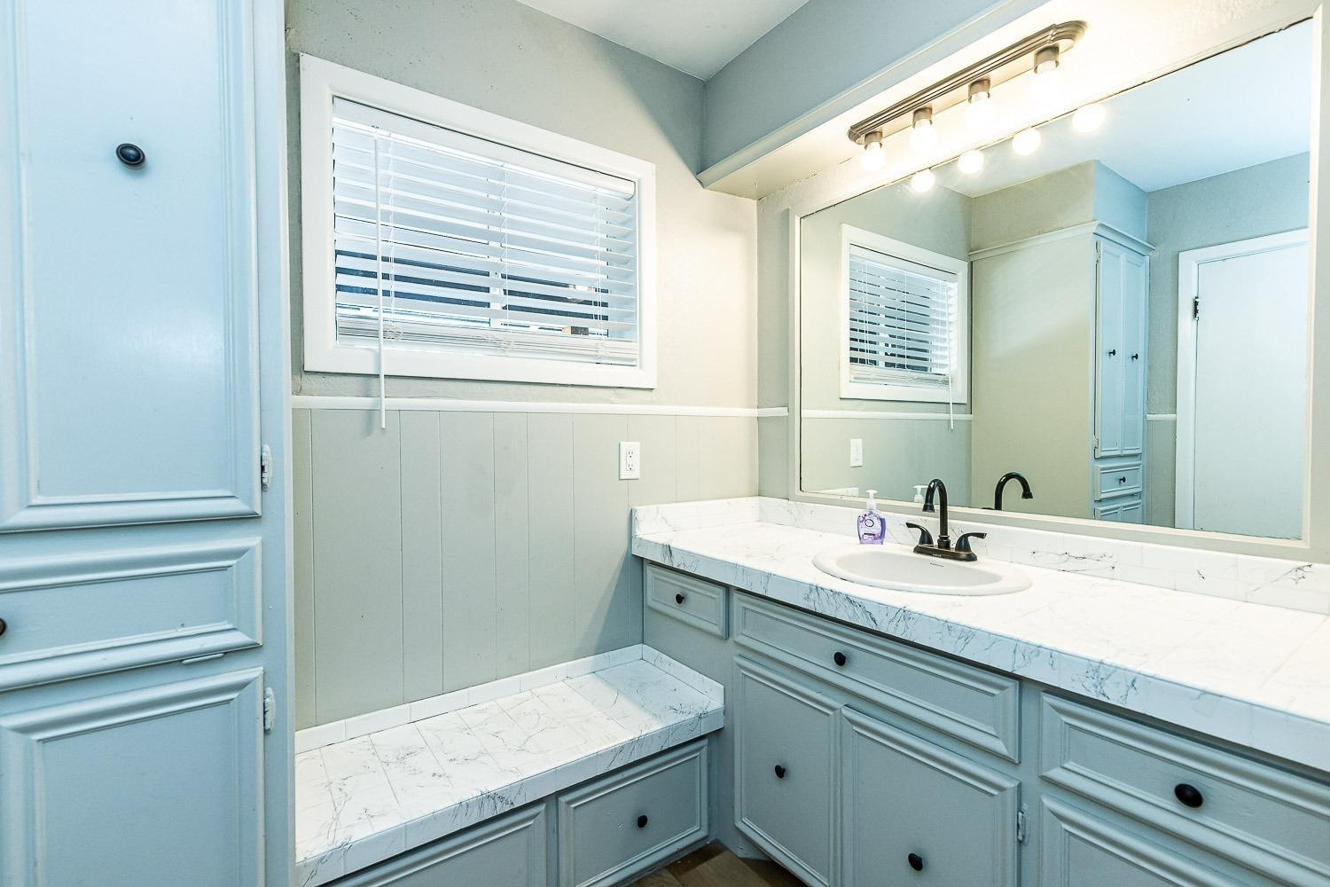 3411 42nd Street Lubbock, TX 79413 - Photo 15 of 33 a bathroom with a granite countertop sink and a mirror